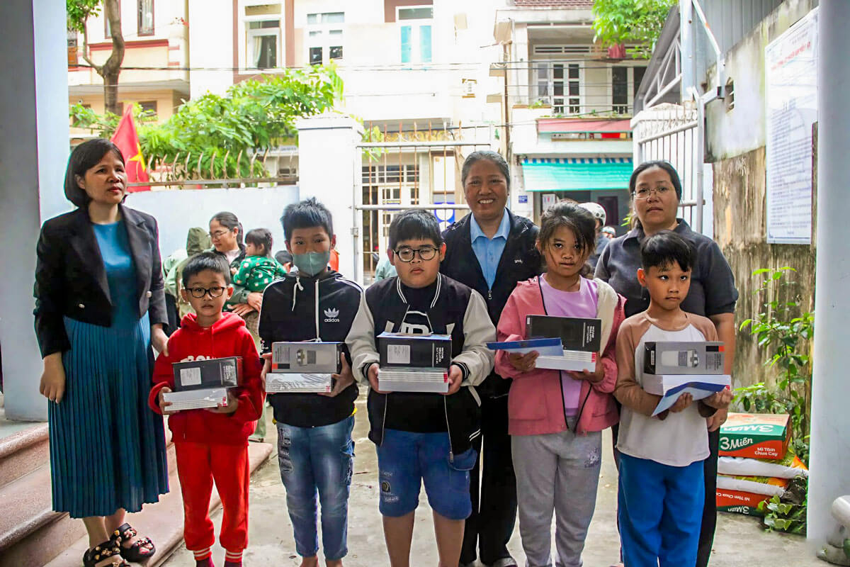 Quý Dì bên Ban Xã Hội - Chương trình phục vụ người khiếm thị - Hội Dòng Mến Thánh Giá Thủ Đức trao quà và chụp ảnh lưu niệm cùng các em học sinh Hội Người Mù tỉnh Gia Lai