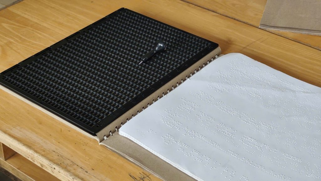 Bảng, dùi và sách chữ nổi (thứ tự từ trái sang phải)